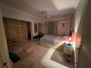 een hotelkamer met een bed en een bank bij Room for transit near airport in Caïro