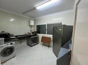 een keuken met een koelkast en een wasmachine bij Room for transit near airport in Caïro