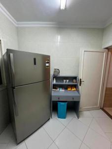 een keuken met een koelkast en een tafel met eten bij Room for transit near airport in Caïro