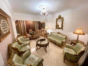 een woonkamer met stoelen, een bank en een tafel bij Room for transit near airport in Caïro