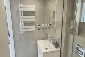 a white bathroom with a sink and a mirror at Holiday Home on Lake Marchowo with Terrace in Koleczkowo +19 photos