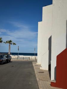 un edificio blanco junto a una playa con palmeras en Cala Sol, en Las Negras