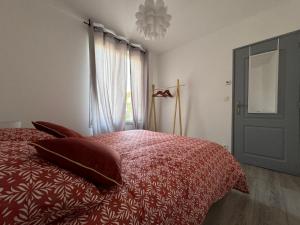 een slaapkamer met een rood bed met kussens en een raam bij Casa Nella, centre et parking, madamedemconciergerie in Reims