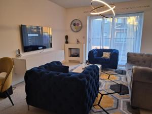 ein Wohnzimmer mit Sofas und einem TV in der Unterkunft Stunning Station Apartment in Kent