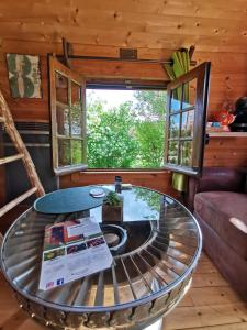 a living room with a glass table in a cabin at La bulle des champs in Champmotteux