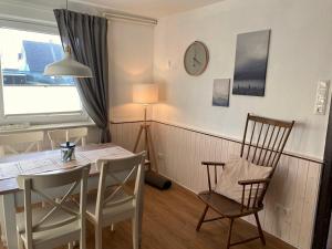 a dining room with a table and chairs and a window at Ferienhaus Sutje in Loose