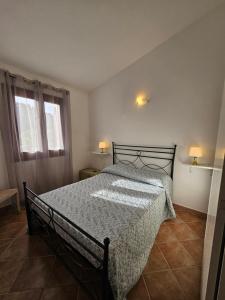 een slaapkamer met een bed en twee ramen bij Villa Angedras in San Teodoro