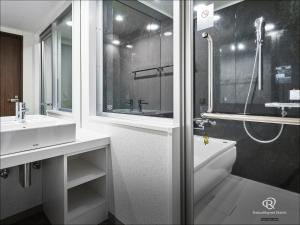 W łazience znajduje się umywalka, wanna i prysznic. w obiekcie Daiwa Roynet Hotel Aomori w mieście Aomori