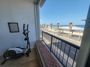 a room with a treadmill and a balcony with a view of the beach at Aparthotel Banana Beach in Tel Aviv