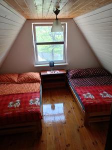 Zimmer im Dachgeschoss mit 2 Betten und einem Fenster in der Unterkunft Dom w Jabłonkach Wakacje, Kaszuby, Chmielno, Sznurki 155 in Chmielno