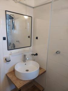 a bathroom with a white sink and a mirror at Aparthotel Banana Beach in Tel Aviv