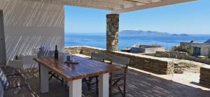 a wooden table on a patio with a view of the ocean at Aloni in Áno Meriá