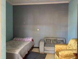 1 dormitorio con 1 cama, 1 sofá y 1 silla en AM Guest House en Kitimē