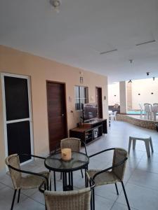 ein Wohnzimmer mit einem Tisch, Stühlen und einem TV in der Unterkunft Bonito é ser Feliz in Recife