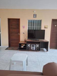 a living room with a flat screen tv on a entertainment center at Bonito é ser Feliz in Recife