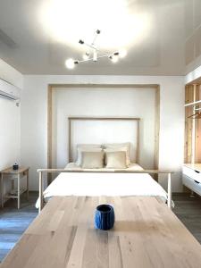 een slaapkamer met een groot wit bed en een tafel bij Studio Sirene at Almar in Năvodari