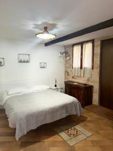 1 dormitorio con cama blanca y techo en taverna Anto en Varcaturo