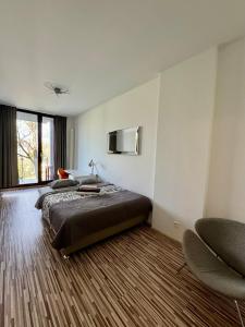 a bedroom with a large bed and two chairs at Two rooms apartment Triton Park in Warsaw