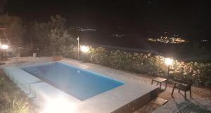 a swimming pool at night with a table and a chair at Casa di sotto in Giratola