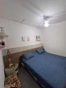 um quarto com uma cama azul e uma ventoinha de tecto em Bonito é ser Feliz no Recife