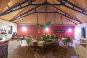 Sharp Island Gorilla Lodge, Lake Bunyonyi في Kashasha: غرفة طعام مع طاولات وكراسي في مبنى