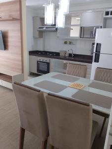a kitchen with a table and chairs in a room at APARTAMENTO LUXUOSO A 1KM DA LITORÂNEA in São Luís
