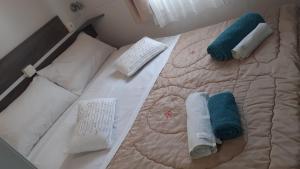 łóżko z białymi i niebieskimi ręcznikami w obiekcie Villa Rosa w mieście SantʼElia