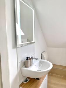 y baño con lavabo y espejo. en CITYNA Apartment Bielefeld - Late Check-Out, en Bielefeld