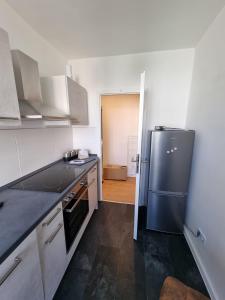 uma cozinha com um frigorífico e uma bancada preta em Beste Apartments em Meerane