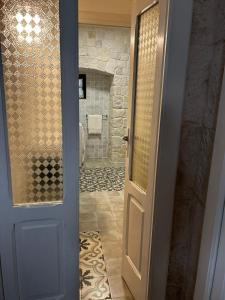 uma porta que leva a uma casa de banho com um chuveiro em Holiday Home Cosimo em Locorotondo