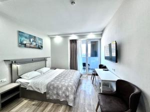 Cette chambre comprend un lit, un bureau et des chaises. dans l'établissement My Sunshine Apartments in Aliance Palace, à Batoumi