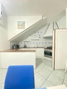 une cuisine avec une chaise bleue et un escalier dans l'établissement Tiffany Holiday Home, à Ischia