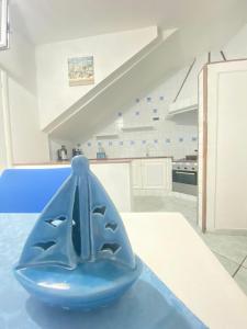 una ciotola blu seduta su un tavolo in una cucina di Tiffany Holiday Home a Ischia