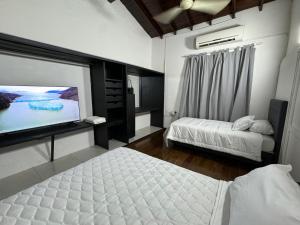 een slaapkamer met 2 bedden en een flatscreen-tv bij Dormitorios a estrenar en el centro de Asunción in Asuncion