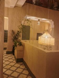 een badkamer met een grote spiegel en een lamp bij Medina Oasis Hostel in Marrakesh