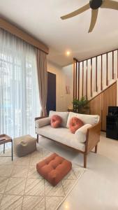 a living room with a couch and a ceiling fan at Kallea Villas in Tlekung +22 photos
