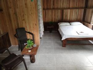 1 dormitorio con 1 cama, 1 mesa y 1 silla en Cabañas Zona Verde, en Nuquí