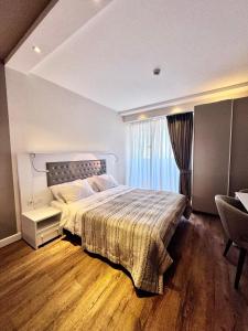 - une chambre avec un grand lit et une fenêtre dans l'établissement My Sunshine Apartments in Aliance Palace, à Batoumi