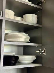 un estante con platos y tazones en una cocina en The Sea Escape Apartment, en Constanţa