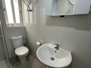 ein weißes Bad mit einem WC und einem Waschbecken in der Unterkunft R3 RN Retreat in St Paul's Bay