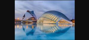 a view of a building with its reflection in the water at Piso Lorena Playa 1min walk in Puerto de Sagunto