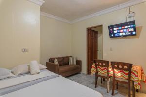 a bedroom with a bed and a couch and a tv at Family Vacation Rentals in La Viva