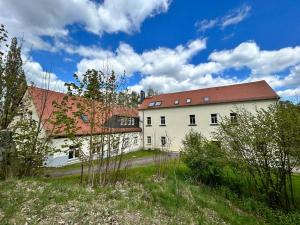 ein großes weißes Gebäude mit rotem Dach in der Unterkunft Ferienwohnung Sprejnik - Residenz Sonnenhübel in Großschönau