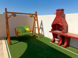 a play room with a swing and a fireplace at دار عزيزي in El Guecheïne