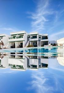 un edificio con reflejo en una piscina de agua en Las Mimosas, en Puerto del Carmen