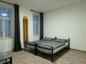 1 dormitorio con 1 cama en una habitación con ventanas en Cukmantl Apartments, en Jeseník