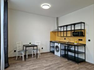 cocina y comedor con mesa y fregadero en Cukmantl Apartments, en Jeseník