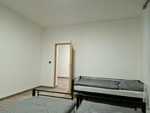 Habitación vacía con 2 camas y espejo en Cukmantl Apartments, en Jeseník