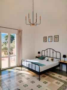 1 dormitorio con cama y lámpara de araña en Villa Bona, en Termini Imerese