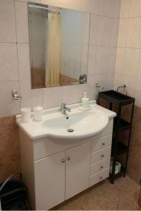 a bathroom with a white sink and a mirror at Ubytování krásném a klidném prostředí V soukromém apartmánu in Aheloy